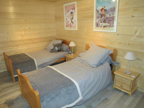 deux lits dans une chambre aux murs en bois dans l'établissement Chalet Gypaète, à La Clusaz