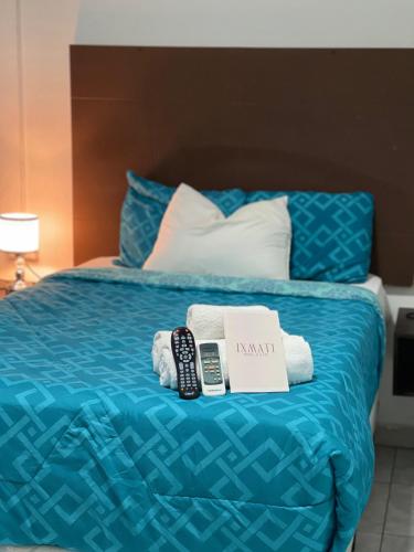 a hotel room with a bed with towels and remotes at Hotel y Café Ixmati Suchitoto in Suchitoto