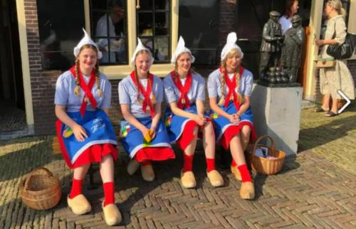 a group of four women sitting on a bench withoodoo at Vakantiebungalow in Riviera Maison stijl nabij zee en strand, bos en duin in Warmenhuizen