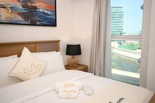 1 dormitorio con 1 cama blanca y ventana en Mariana Luxurious 2BR Apartment, en Abu Dabi
