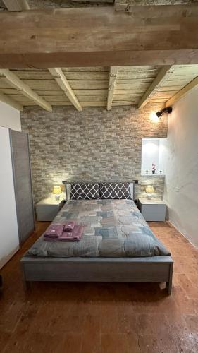 una camera con un grande letto in un muro di mattoni di Bilocale Palazzolo - Free WiFi e Netflix a Palazzolo sullʼOglio