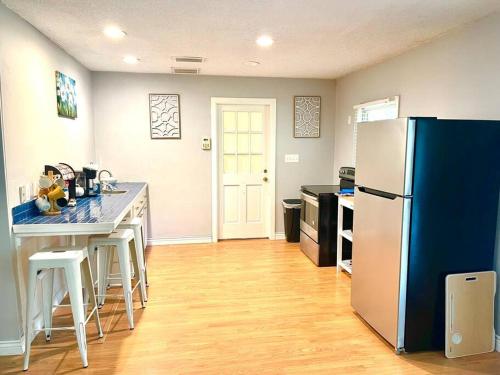 a kitchen with a refrigerator and a table with stools at Town & Country Hideaway - 1BR/1BA, 20 min FAMU/FSU in Tallahassee