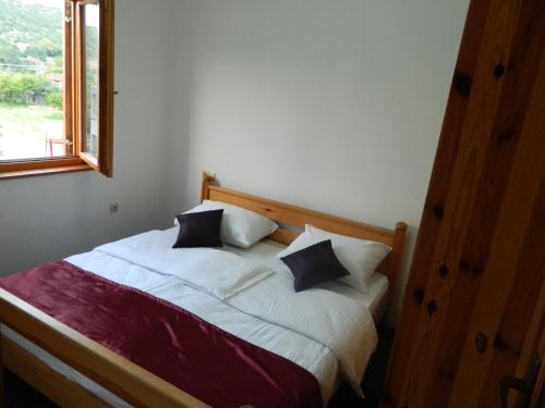 a bedroom with a bed with pillows and a window at Motel Jelčić in Čapljina