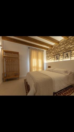 - une chambre avec 2 lits et un mur en pierre dans l'établissement MEDITERRÀNIA RURAL, à Cabanes
