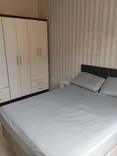 Schlafzimmer mit einem großen weißen Bett und Schränken in der Unterkunft Apartamento aconchegante in Rio das Ostras