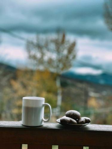 a cup of coffee and two rocks on a balcony at Cottage Racha Rhymes in Ambrolauri