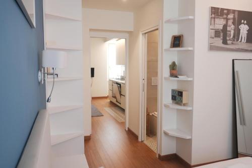 ein Zimmer mit weißen Wänden und einer Tür mit einer Küche in der Unterkunft Spazio Stoppani - Liberty 28 in Mailand