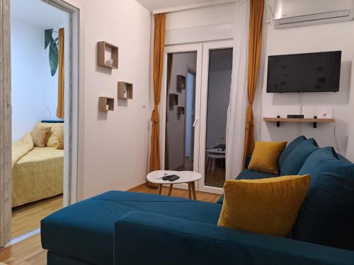 a living room with a blue couch and a tv at Dream Apartment in Vrnjačka Banja