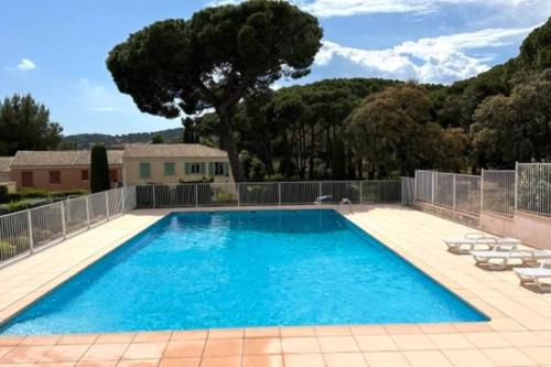 une grande piscine avec des chaises et une clôture dans l'établissement Appartement A02 les Pins Bleus, à Sainte-Maxime