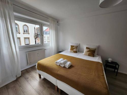 een slaapkamer met een bed met twee handdoeken erop bij Logement familial/ Orangerie in Straatsburg