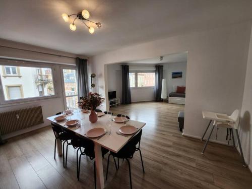 een eetkamer met een tafel en stoelen in een woonkamer bij Logement familial/ Orangerie in Straatsburg
