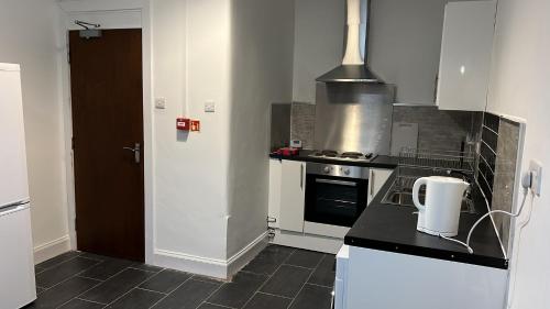 uma cozinha com um fogão e uma bancada em Large 3 Bed Apt close to city, OVO Hydro and Ibrox Stadium em Glasgow