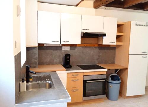 une cuisine avec des armoires blanches et un évier dans l'établissement Élégante maison centre Romilly, à Romilly-sur-Seine