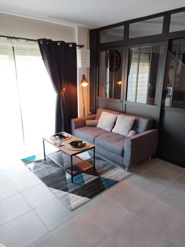 a living room with a couch and a coffee table at AJC Ô Spa in Saulzoir