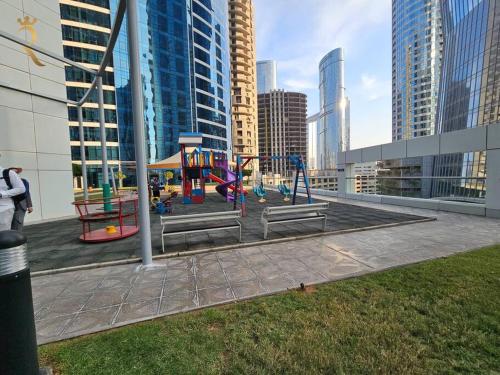 a playground in the middle of a city with tall buildings at Majestic Studio - Cozy Living in Al Reem, Near Reem Mall in Abu Dhabi