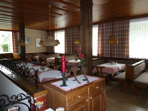 a restaurant with tables and chairs and a red candle at Pension Edelweiss in Sankt Martin am Tennengebirge