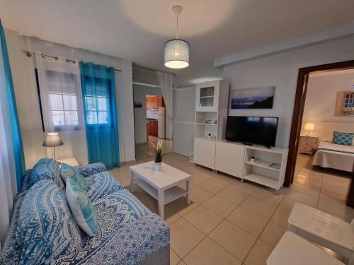 a living room with a couch and a tv at Chinijo Beach in Caleta de Sebo