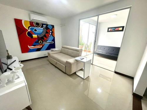 a living room with a couch and a painting on the wall at Casa completa con Aire Acondicionado, Calentador de Agua & Garaje privado in Palmira