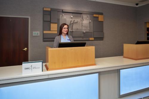 a woman sitting at a counter with a laptop at Holiday Inn Express Hotel & Suites Rochester Webster by IHG in Webster