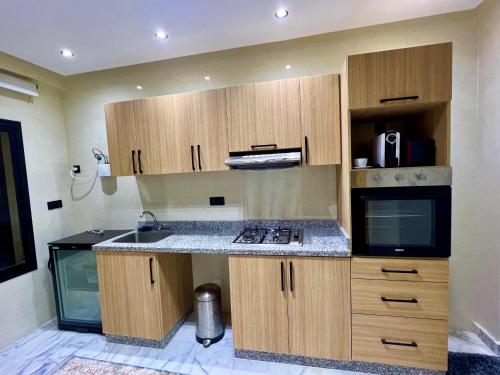 a kitchen with wooden cabinets and a counter top at Appartement Royal in El Jadida