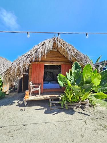 eine Hütte mit einem Bett und einem Stuhl darin in der Unterkunft Saona lodge in Mano Juan
