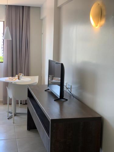 una scrivania con una televisione sopra di Coral Ritz - Flat beira mar (Condomínio Ritz Suites Home Service) a Maceió