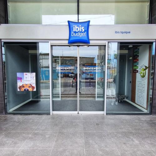 uma frente de loja com um sinal de up na porta em ibis budget Iquique em Iquique