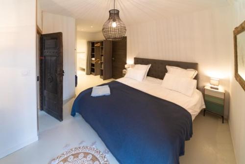 ein Schlafzimmer mit einem großen Bett mit einer blauen Decke in der Unterkunft Gîtes de coussane in Espalion