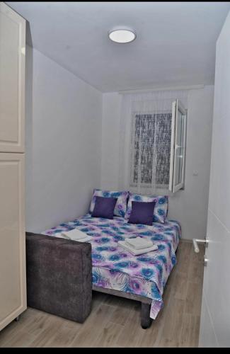 Zimmer mit einem Sofa und lila Kissen in der Unterkunft DM apartman in Ruma