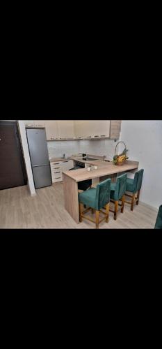 eine Küche mit Tisch und Stühlen und einer Theke in der Unterkunft DM apartman in Ruma
