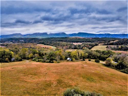 an open field with trees and mountains in the background at Heartstone Country Retreat in Buena Vista