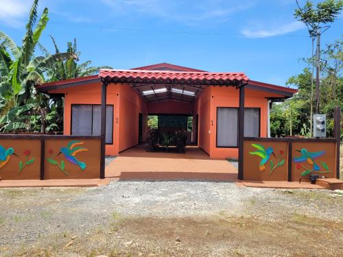 ein Haus mit einem Tor mit bunten Gemälden darauf in der Unterkunft COLIBRÍ TINY HOUSES in Fortuna