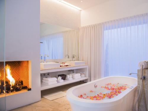a bathroom with a bath tub and a fireplace at Anticavilla Hotel in Cuernavaca