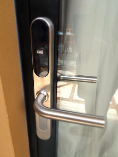 a close up of a glass door with a metal handle at Pousada Kirana in Praia do Rosa