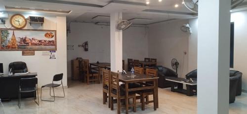 バラナシにあるBhardwaj Darbarのダイニングルーム(テーブル、椅子、壁掛け時計付)