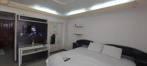 um quarto com uma cama e uma televisão de ecrã plano em Riverfront Retreat Prime Location Apartment with Stunning Views of the RioNegro em Manaus