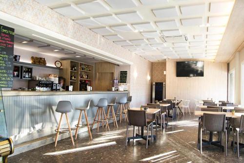 um restaurante com um bar com cadeiras e mesas em San Luis em Vilaboa