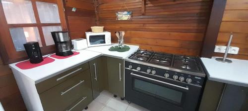 eine Küche mit einem Herd und einer Mikrowelle in der Unterkunft Le Chalet Tropical in Le François