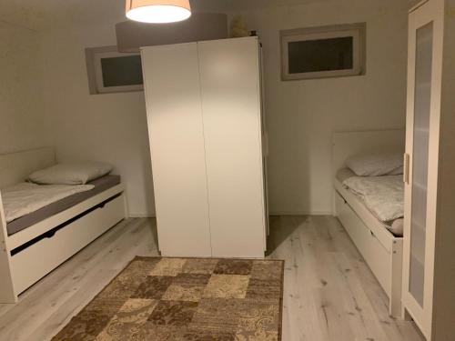 a room with two beds and a white cabinet at Messe Apartment in Hannover