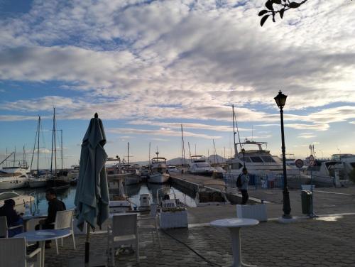 a marina with tables and an umbrella and boats at Maria in Sidi Bou Saïd