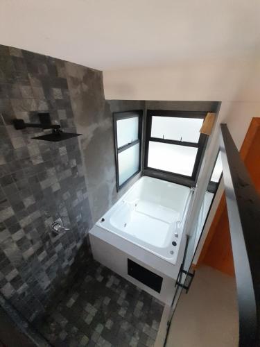 a bathroom with a white sink and a window at Pousada Kirana in Praia do Rosa