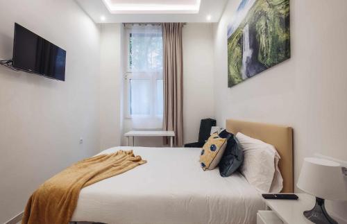 - une chambre avec un lit et une télévision murale dans l'établissement Lujo exclusividad espacioso Madrid centro, à Madrid
