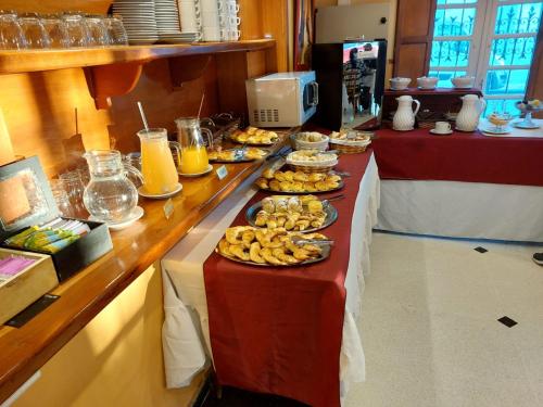 a buffet line with plates of food and drinks at Hotel Francia in Tandil