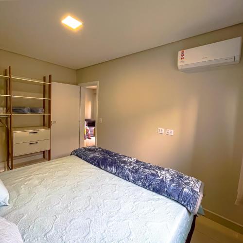 a bedroom with a bed and a air conditioner on the wall at Apto Adilson in Foz do Iguaçu
