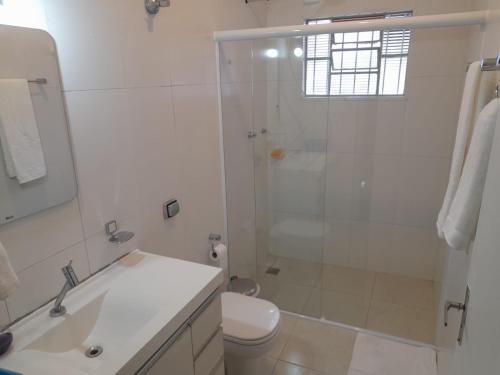 a bathroom with a shower and a toilet and a sink at Quarto com duas camas de solteiro in Itu