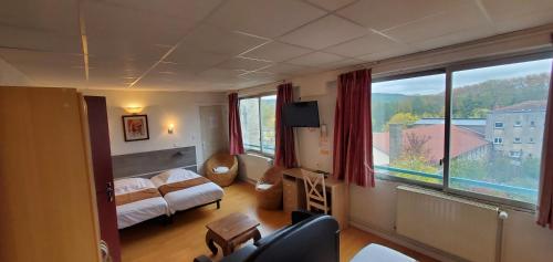 una camera con un letto e una grande finestra di Hotel Bar Restaurant Saint Paul a Verdun-sur-Meuse