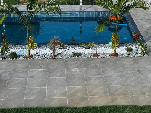 einen Pool mit Palmen und Pflanzen im Hof in der Unterkunft Casa Praia Rios in Entre Rios