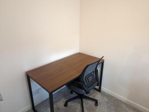 a wooden desk with a chair in a room at Great Location, large 1 bed flat with parking in Broughty Ferry