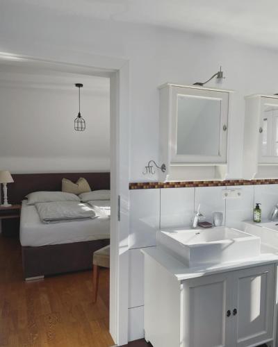 a white bathroom with a sink and a bed at Casa Anna in Villach