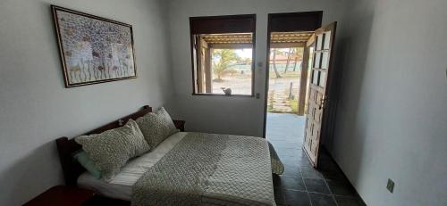 1 dormitorio con 1 cama y puerta abierta en Pousada Marinheiro en Sítio